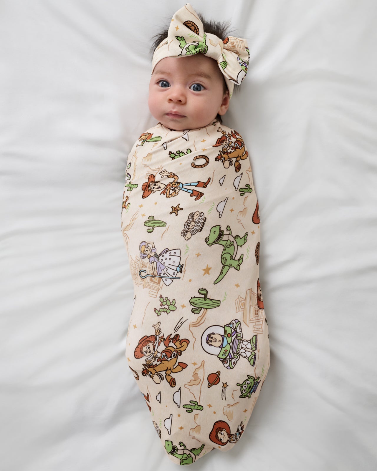 Aerial view of the Disney & Pixar Woody's Wild West Swaddle & Luxe Bow Headband Set