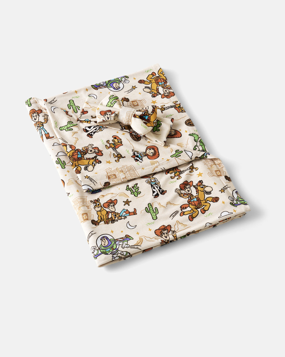 Flat lay of the Disney & Pixar Woody's Wild West Swaddle & Luxe Bow Headband Set
