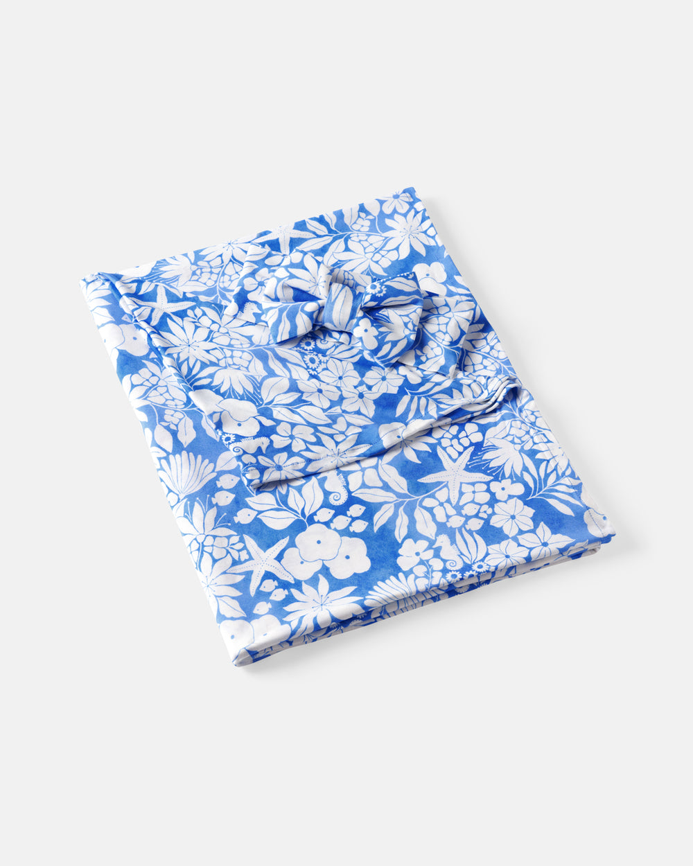 Flat lay of the Azure Garden Swaddle & Luxe Bow Headband Set