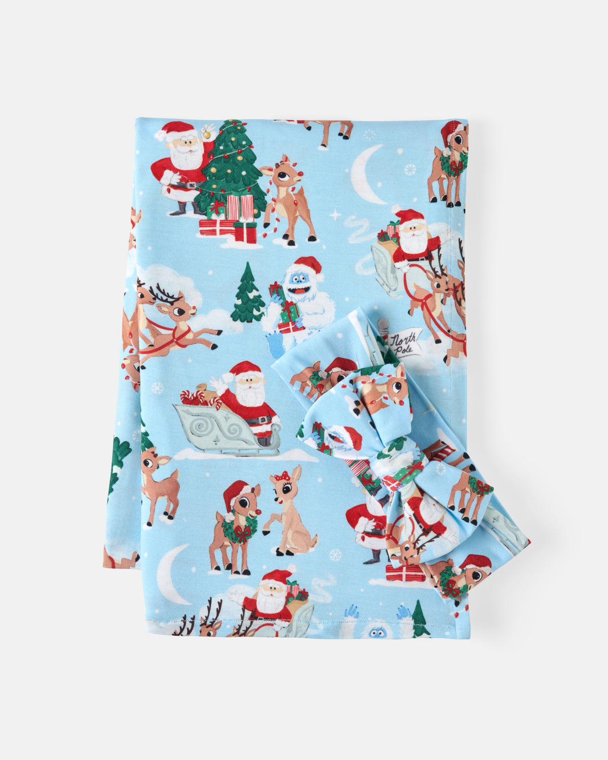 A folded swaddling blanket with a festive Christmas print featuring Santa Claus, reindeer, snowman, Christmas tree, and snowflakes, displayed on a clean white background.