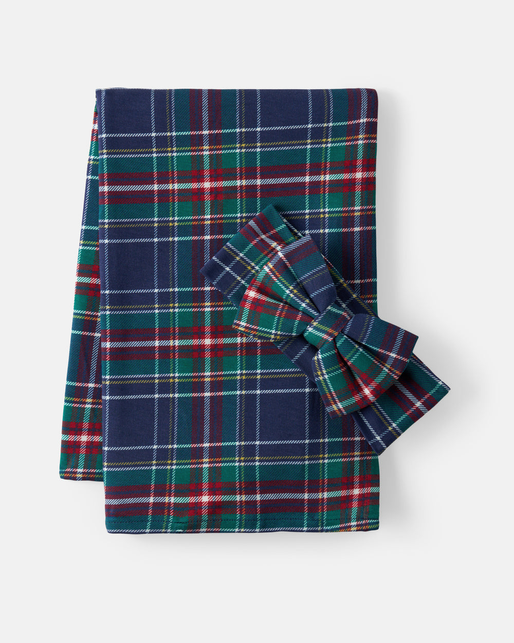 A folded plaid fabric item with a matching bow, shown on a clean light gray background. The plaid pattern features navy blue, green, red, white, and thin yellow stripes.