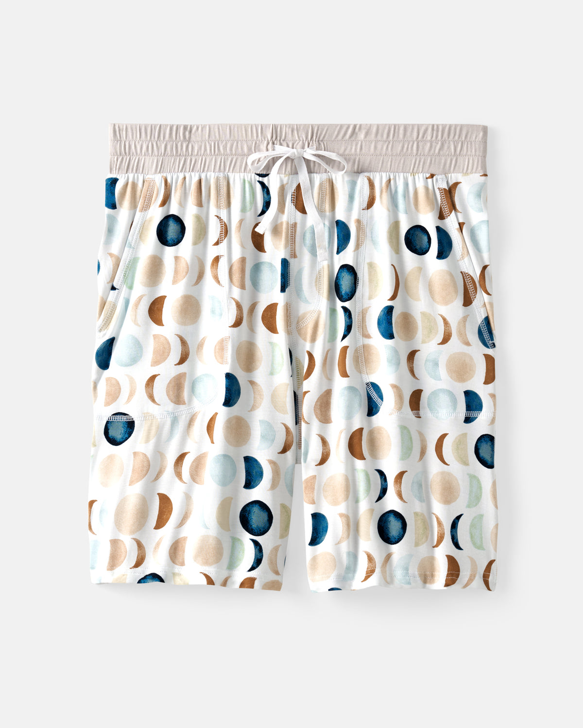 A pair of men's lounge shorts featuring a white base with a repeating pattern of watercolor-style beige, brown, and navy blue crescent moons and dots, finished with a light beige elastic waistband and drawstring.