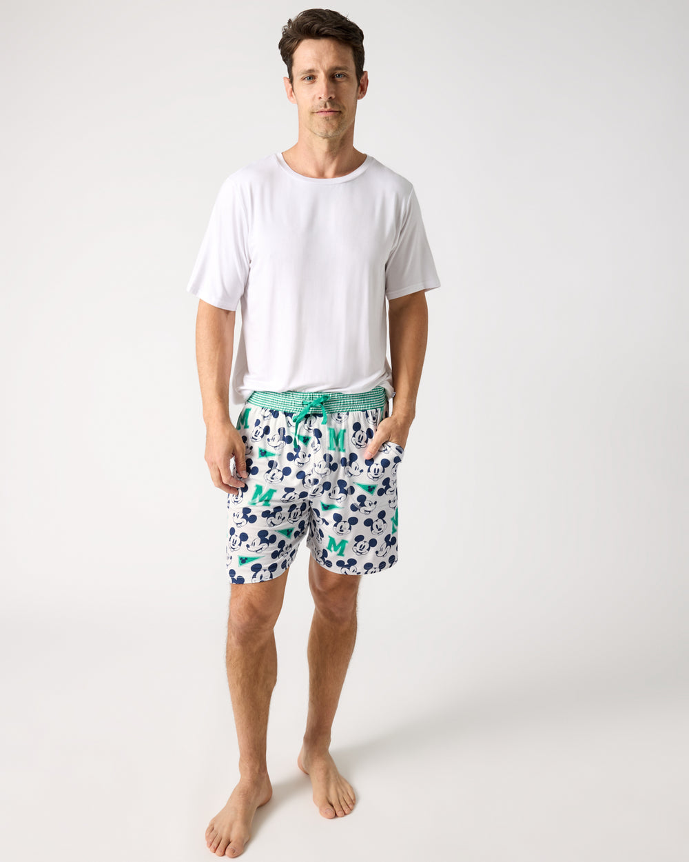 Man wearing the Disney Varsity Mickey Mouse Men's Pajama Shorts and White Top