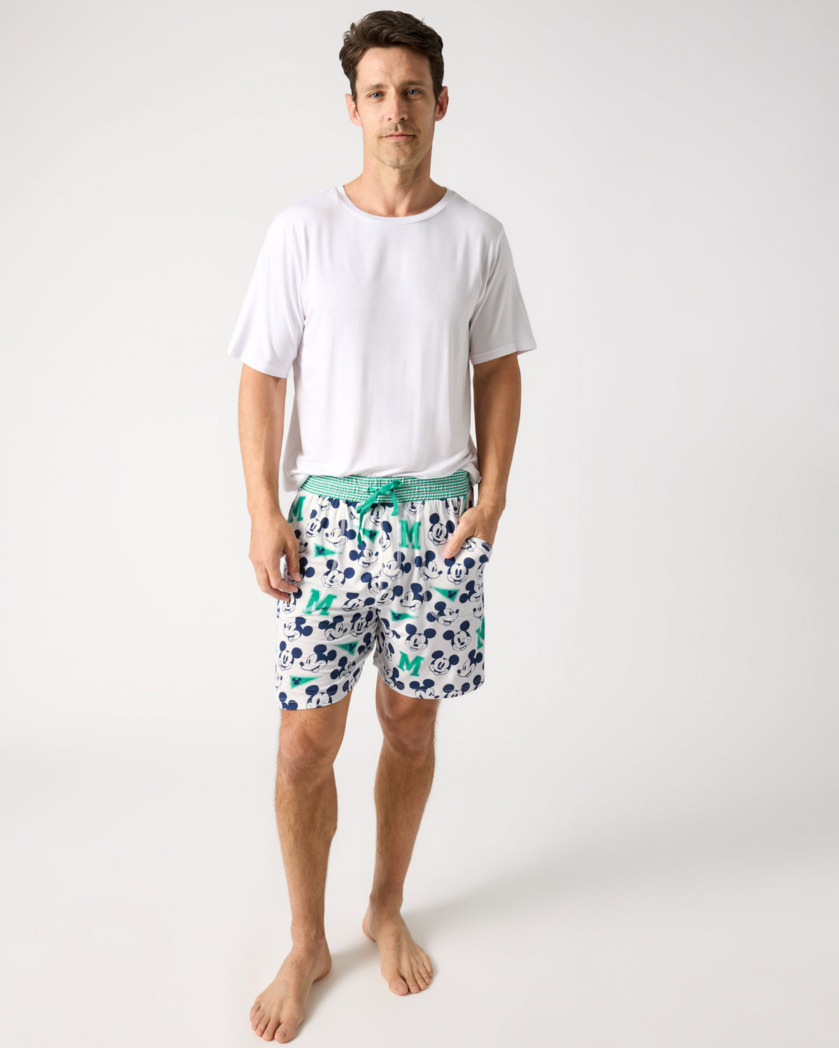 Man wearing the Disney Varsity Mickey Mouse Men's Pajama Shorts and White Top