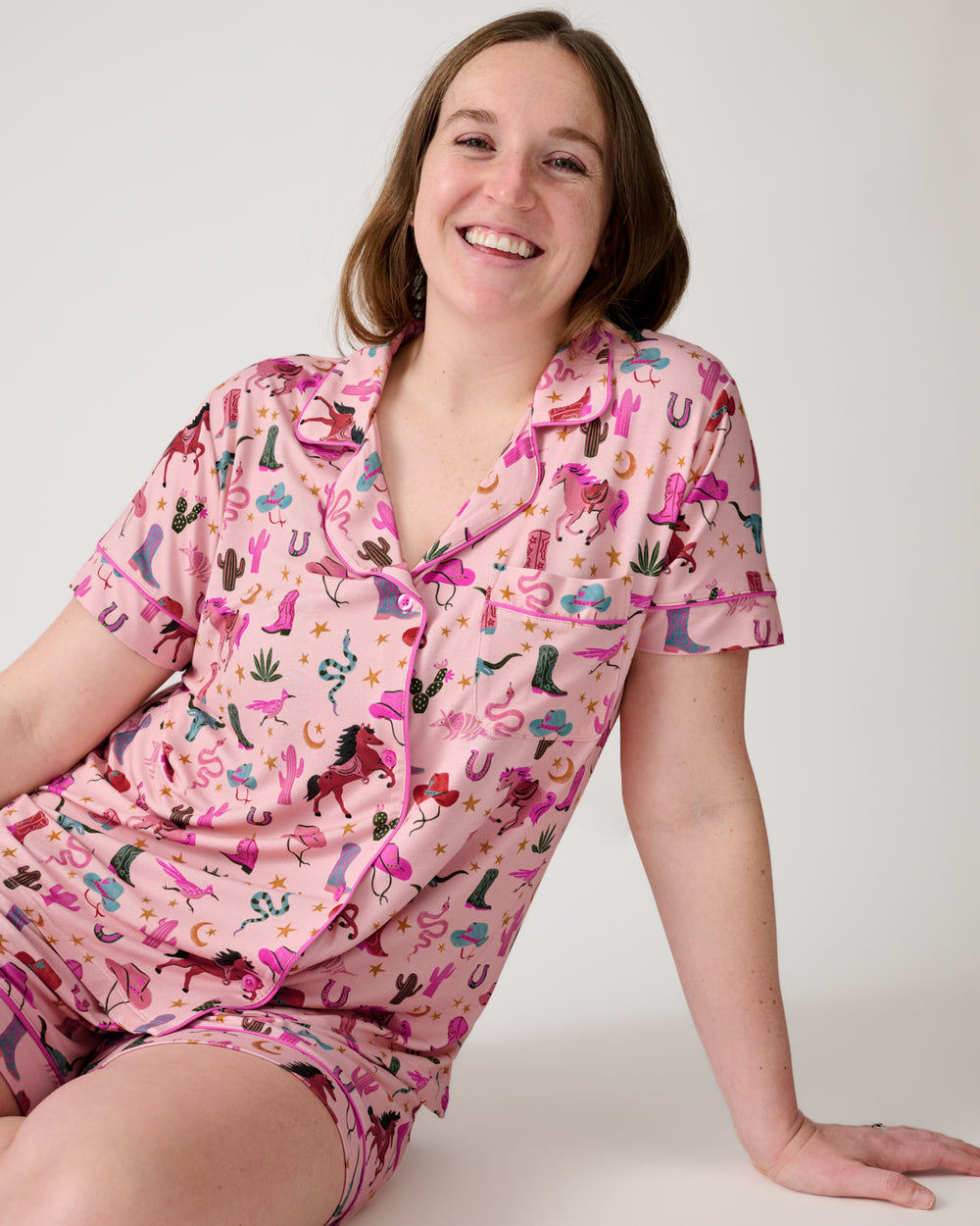 Sitting woman wearing the Pink Rancher Roundup Women's Short Sleeve & Shorts Pajama Set