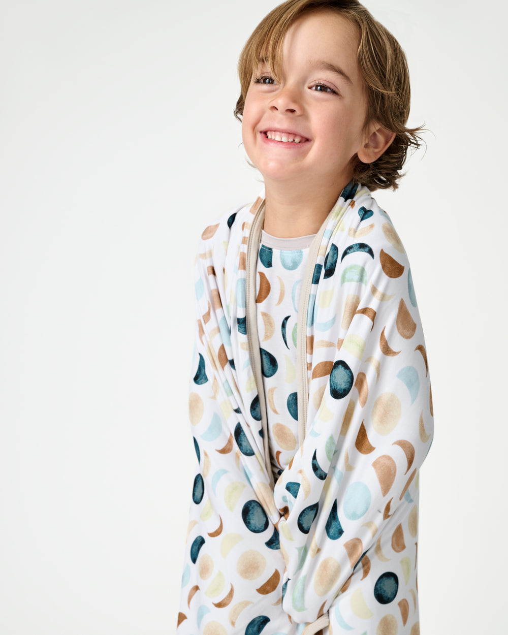Close up of boy wrapped in the Luna Neutral Large Cloud Blanket®