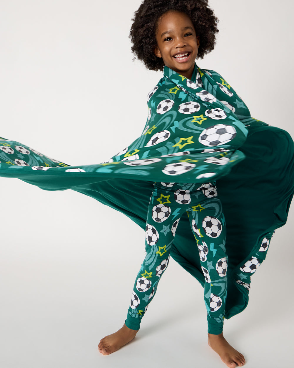Child in motion wrapped in the Soccer Stars Large Cloud Blanket®