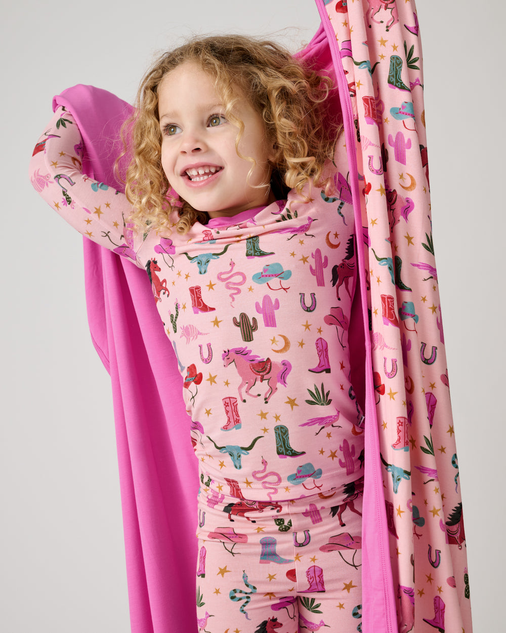 Close up of girl holding the Pink Rancher Roundup Large Cloud Blanket® wearing matching pajamas