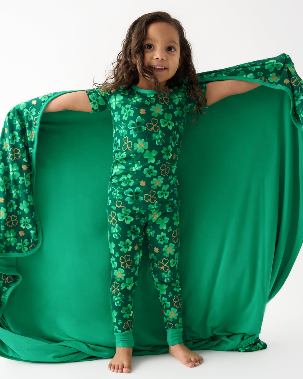 Girl holding the Clover Cuties Large Cloud Blanket® wearing matching pajamas