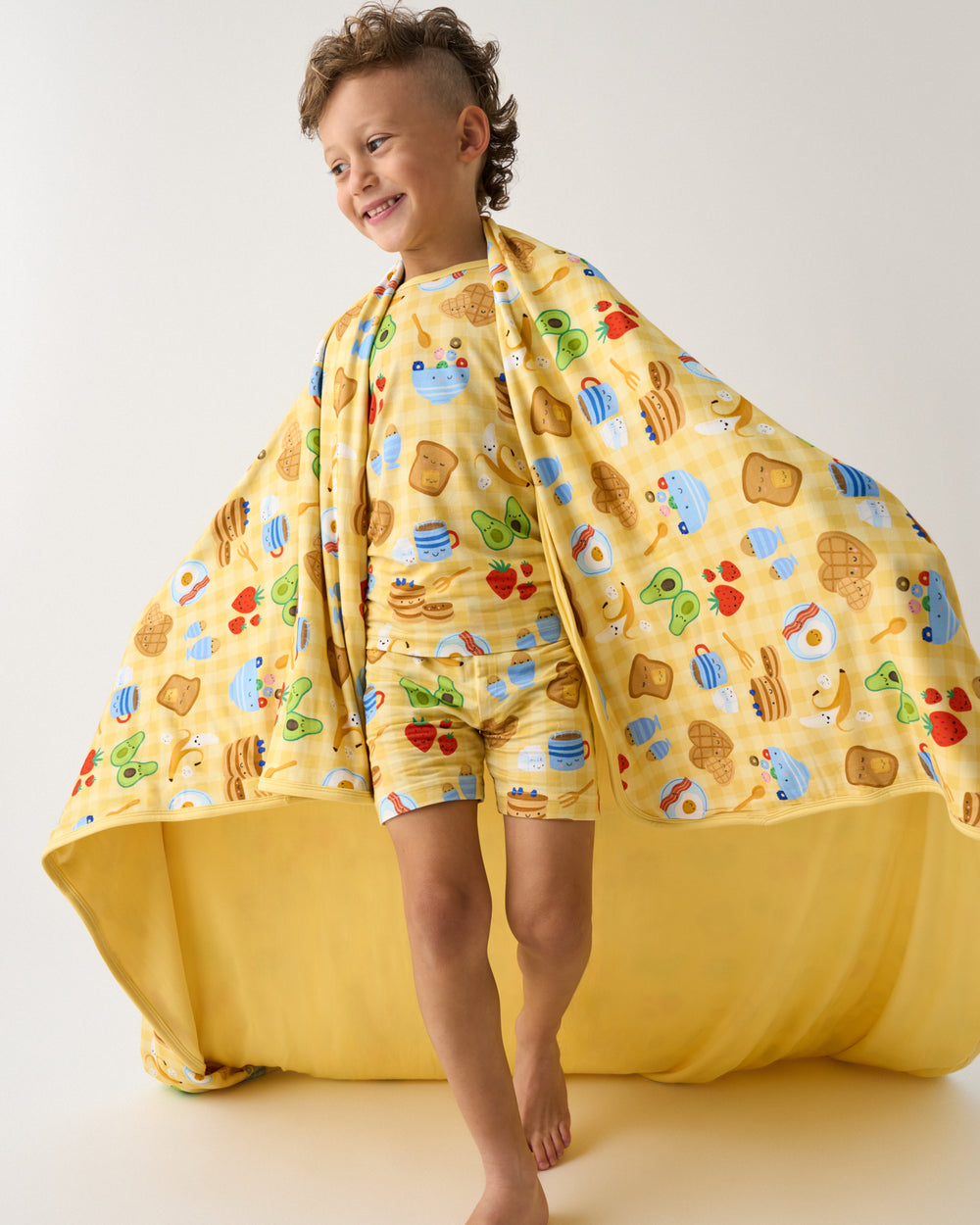 Boy wrapped in the Breakfast Bunch Large Cloud Blanket®