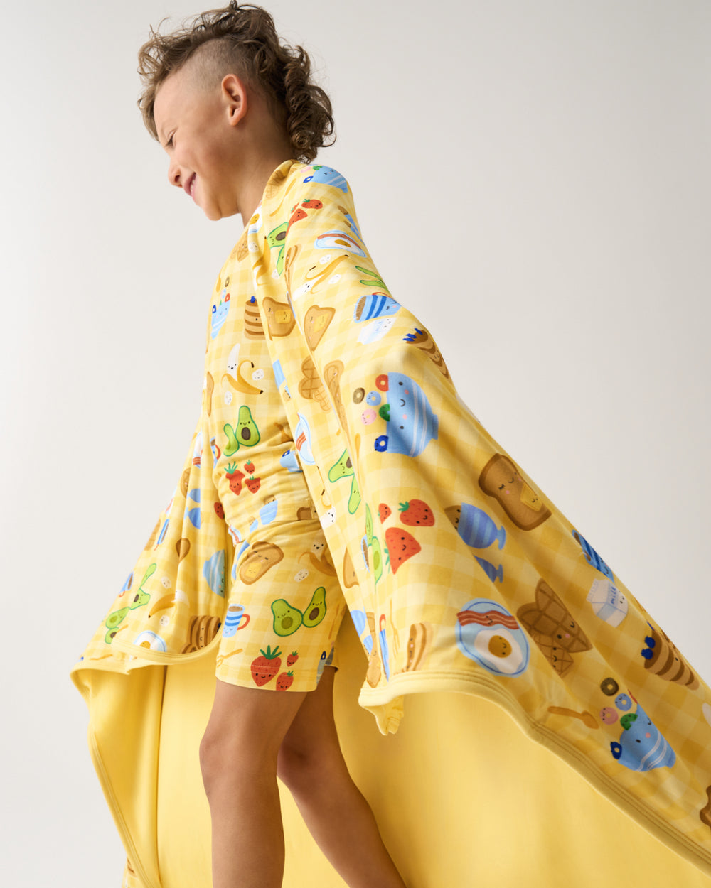 Boy wrapped in the Breakfast Bunch Large Cloud Blanket® wearing matching pjs