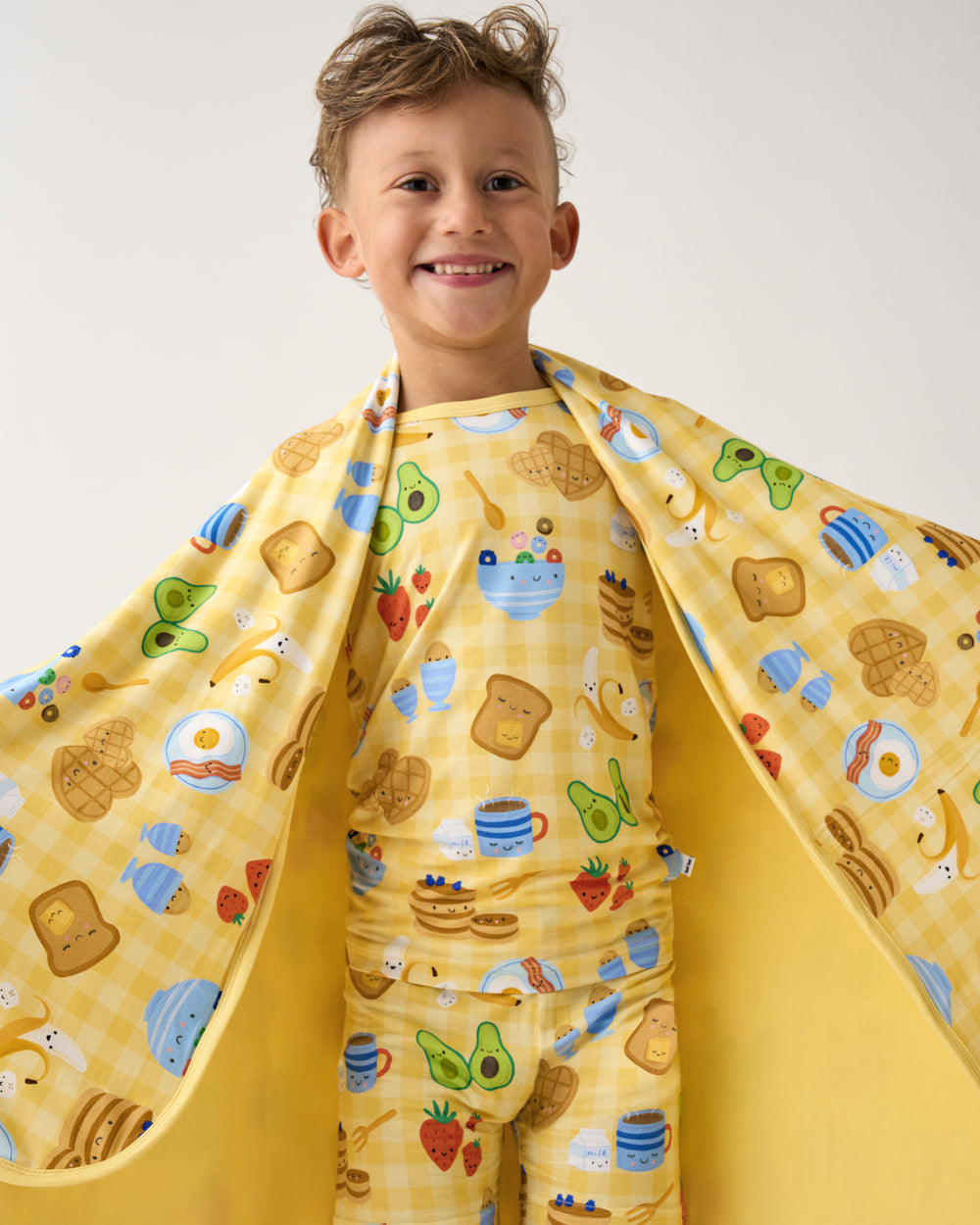Close up of boy covered in the Breakfast Bunch Large Cloud Blanket®