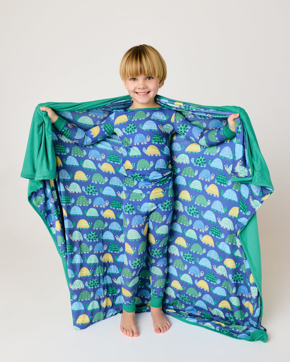Boy holding up the Shell Parade Large Cloud Blanket®