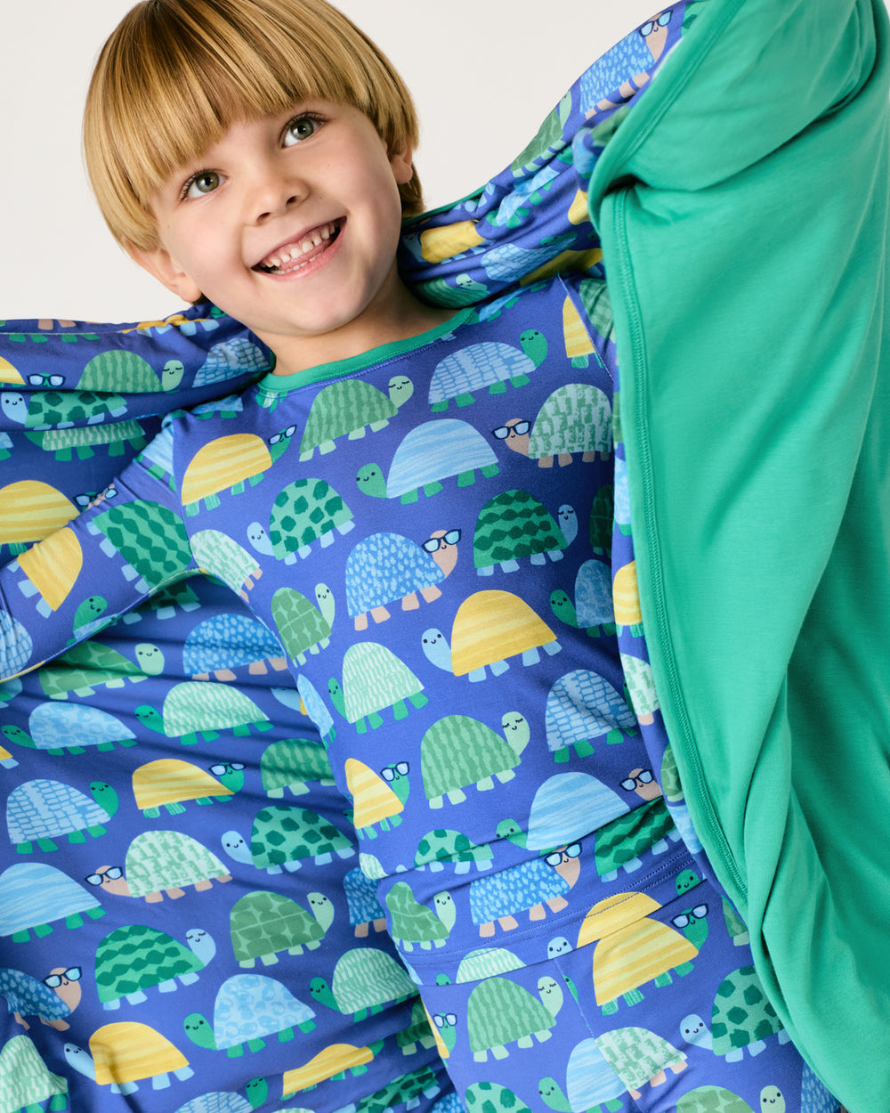 Close up of boy holding up the Shell Parade Large Cloud Blanket®