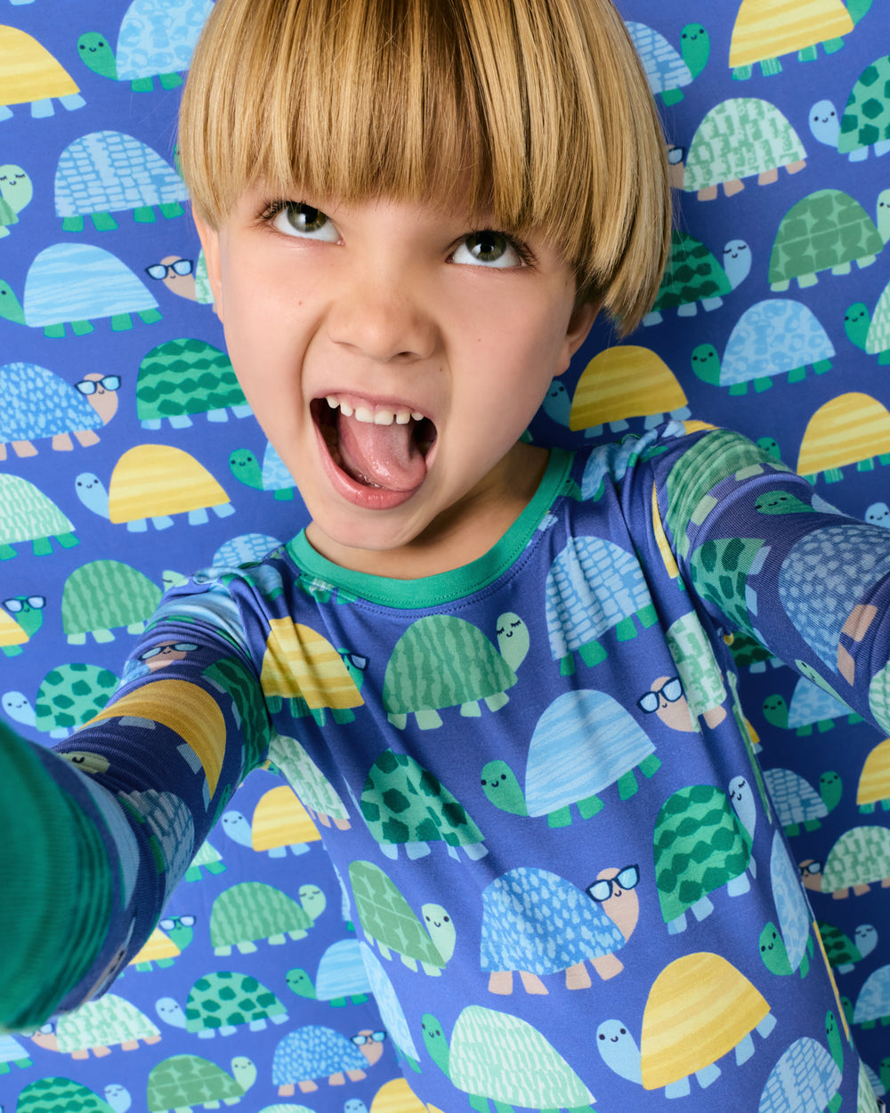 Child standing in front of the Shell Parade Large Cloud Blanket®