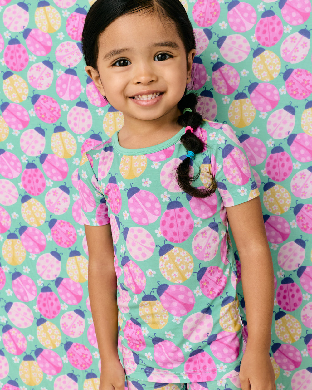 Girl standing in front of the Ladybug Meadow Large Cloud Blanket®