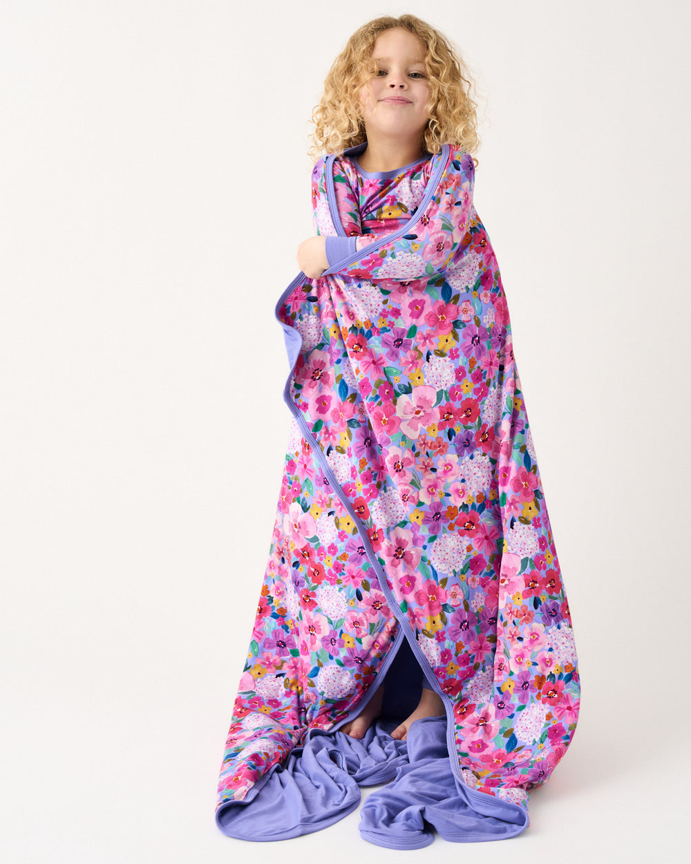 Standing girl wrapped in the Sweet Sprigs Large Cloud Blanket®