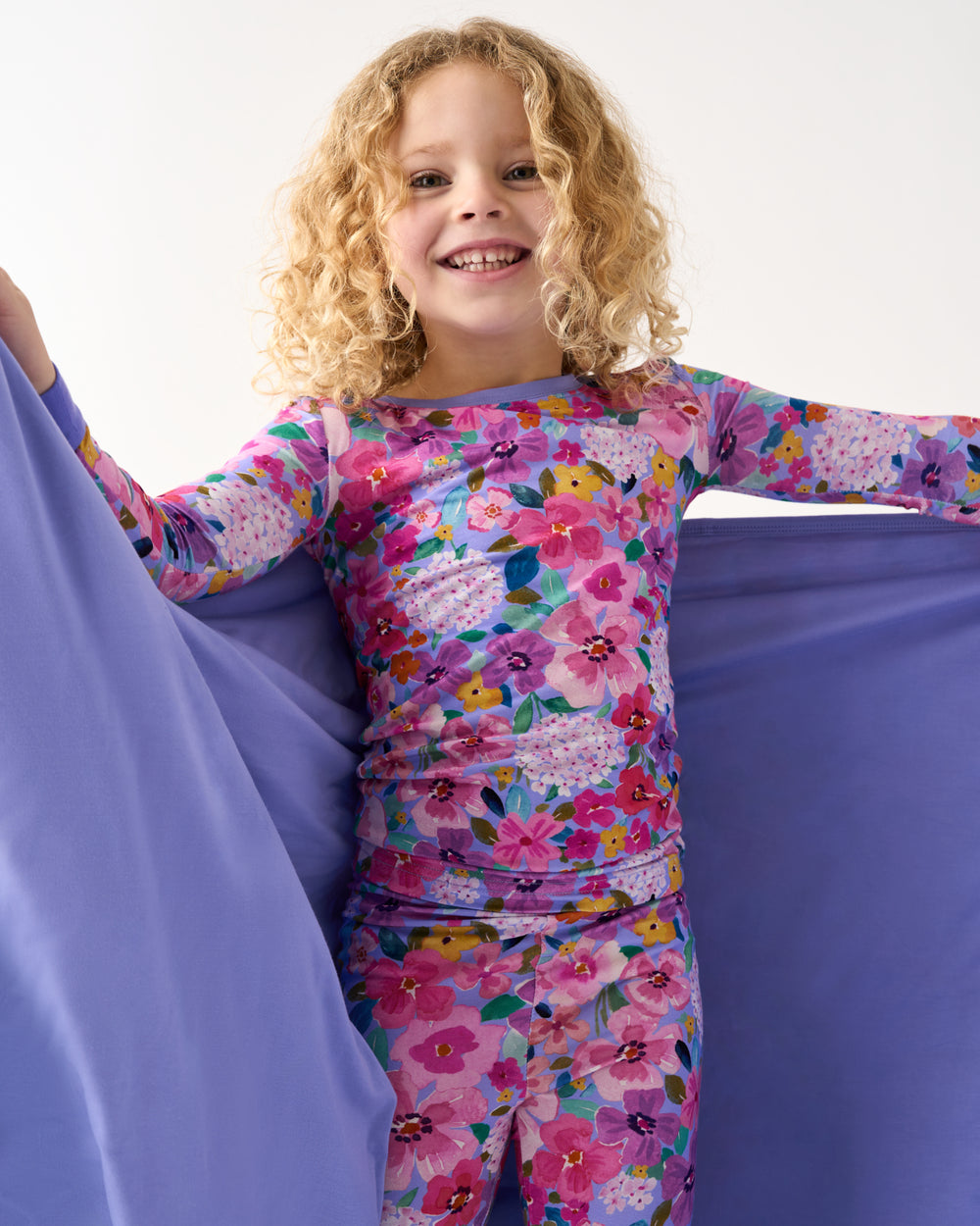 Close up of girl holding up the Sweet Sprigs Large Cloud Blanket® showing the solid purple side