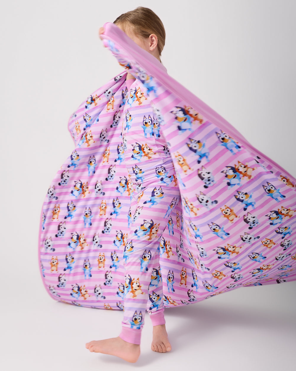 Child in motion holding the Pink Bluey Dance All Day Large Cloud Blanket®