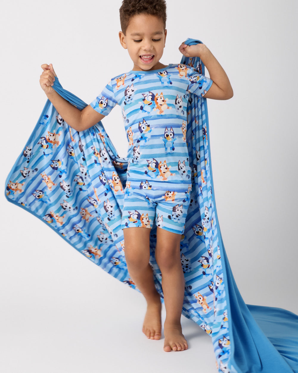 Child in motion holding the Bluey Dance All Day Large Cloud Blanket®