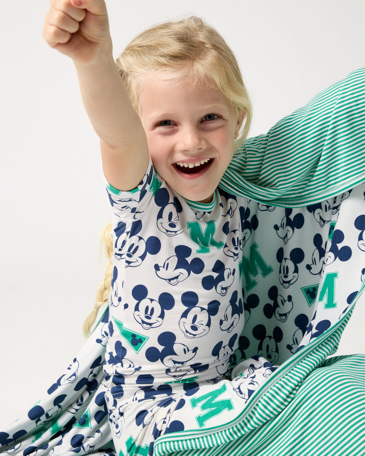 Girl wrapped in the Disney Varsity Mickey Mouse Large Cloud Blanket® wearing matching PJs