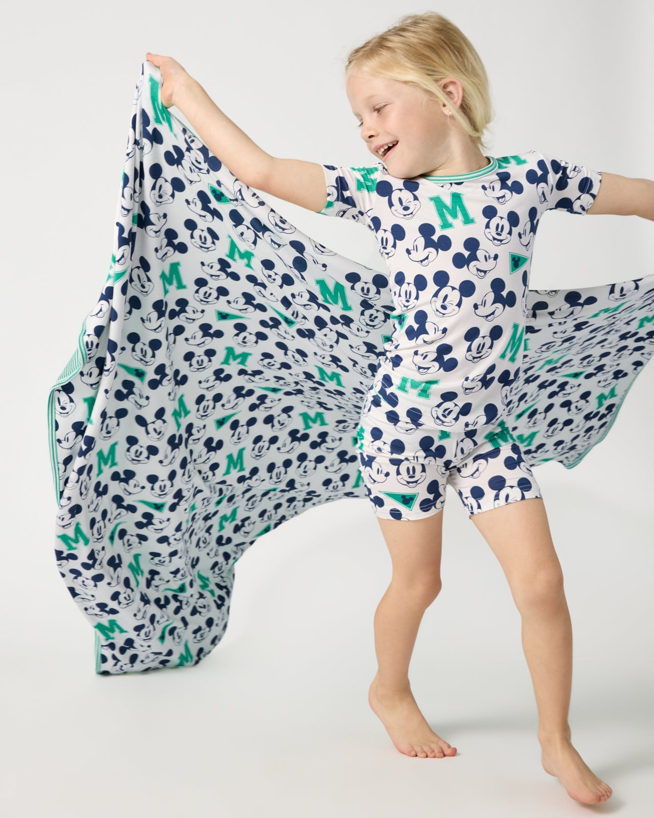 Child in motion holding the Disney Varsity Mickey Mouse Large Cloud Blanket®