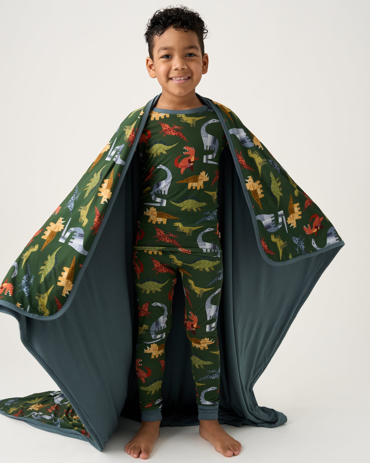 Standing boy wrapped in the Green Roar & Explore Large Cloud Blanket®