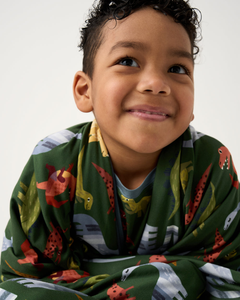 Close up of child wrapped in the Green Roar & Explore Large Cloud Blanket®