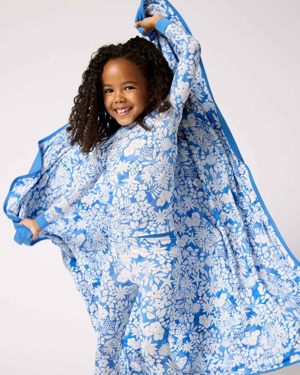 Girl holding the Azure Garden Large Cloud Blanket® up