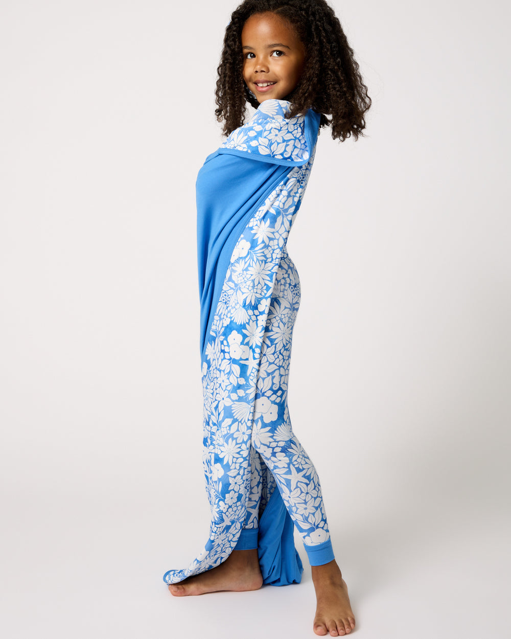 Standing girl wrapped in the Azure Garden Large Cloud Blanket®