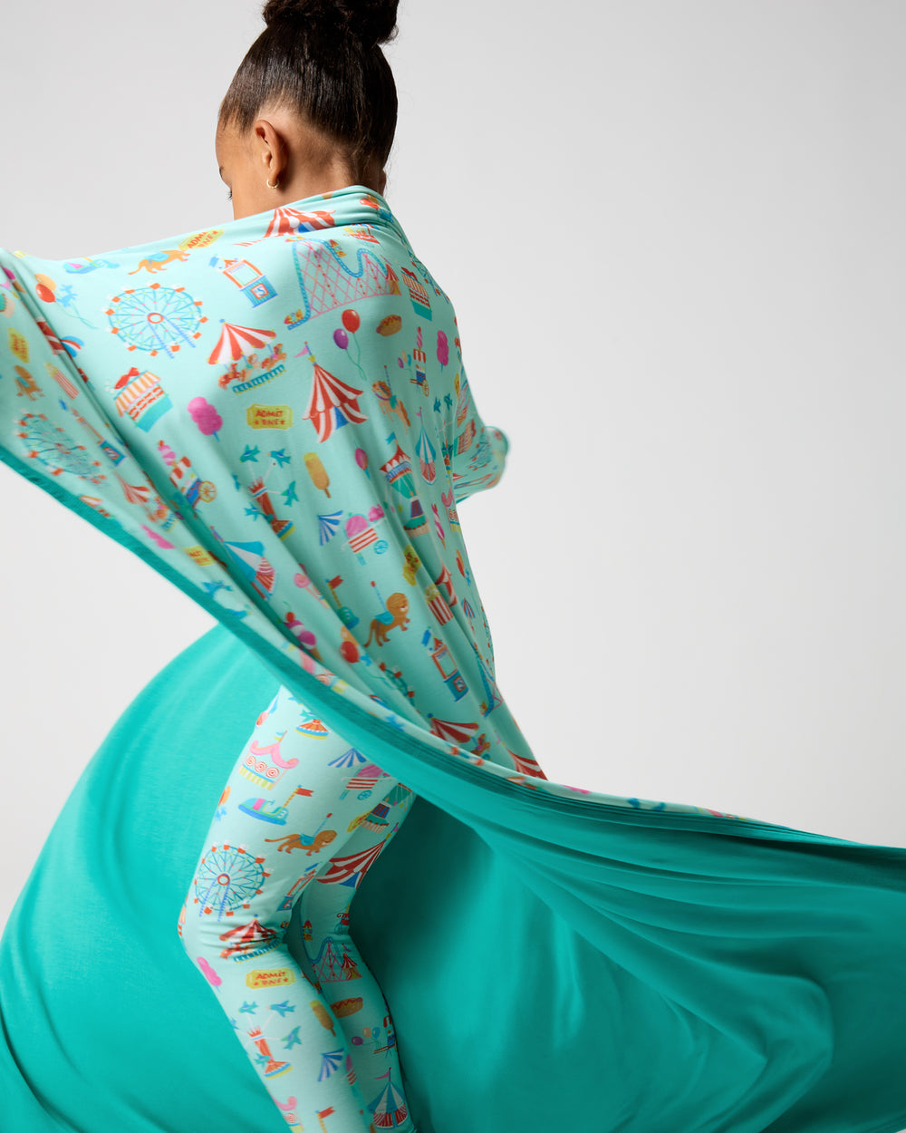 Child in motion wrapped in the Fizzy Fair Large Cloud Blanket®