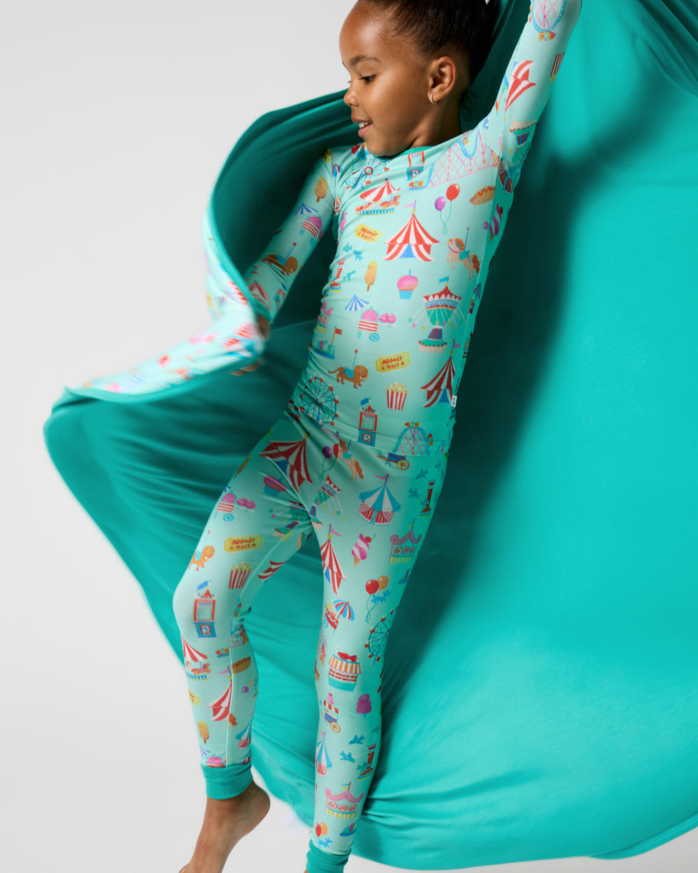 Girl holding out the Fizzy Fair Large Cloud Blanket® showing the solid teal side