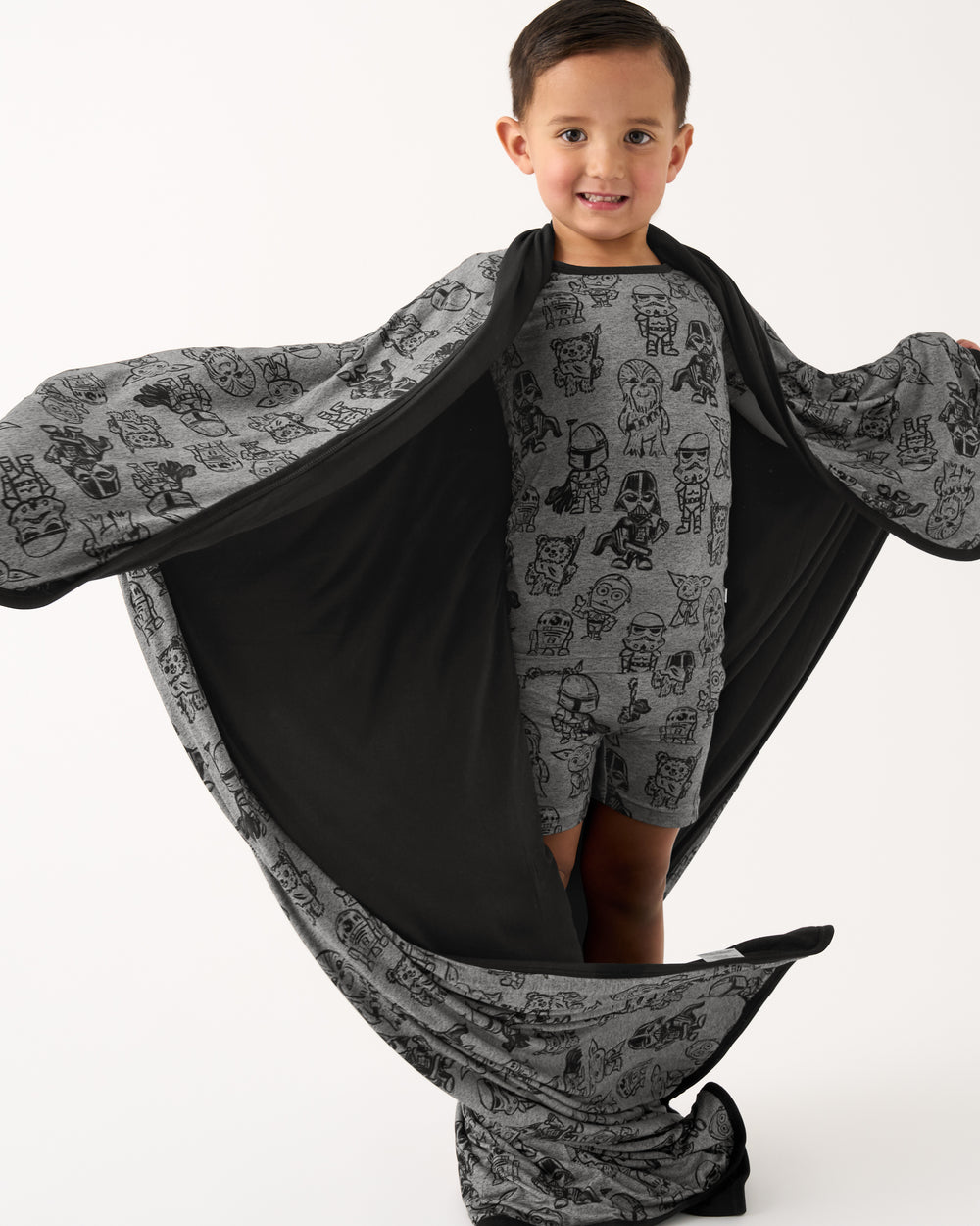 Boy holding out the Star Wars Far, Far, Away Friends Large Cloud Blanket® showing the black side
