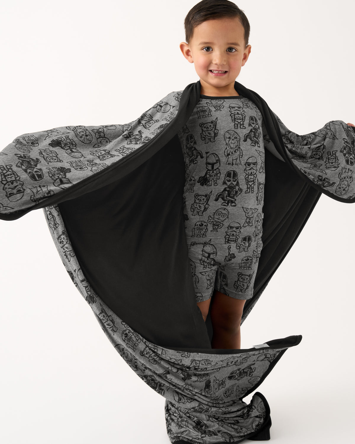 Boy holding out the Star Wars Far, Far, Away Friends Large Cloud Blanket® showing the black side