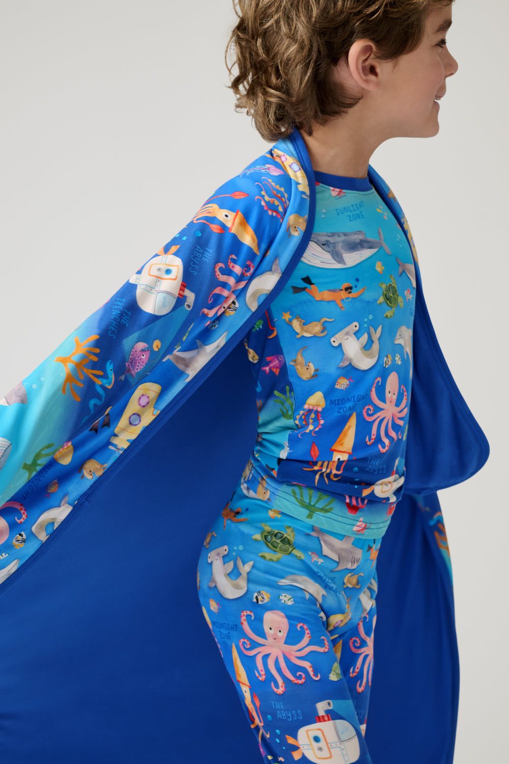Close up of child wrapped in the Underwater Discovery Large Cloud Blanket® 