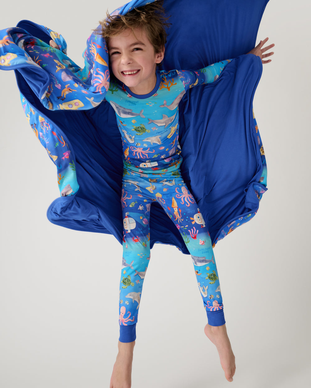 Child jumping with the Underwater Discovery Large Cloud Blanket®