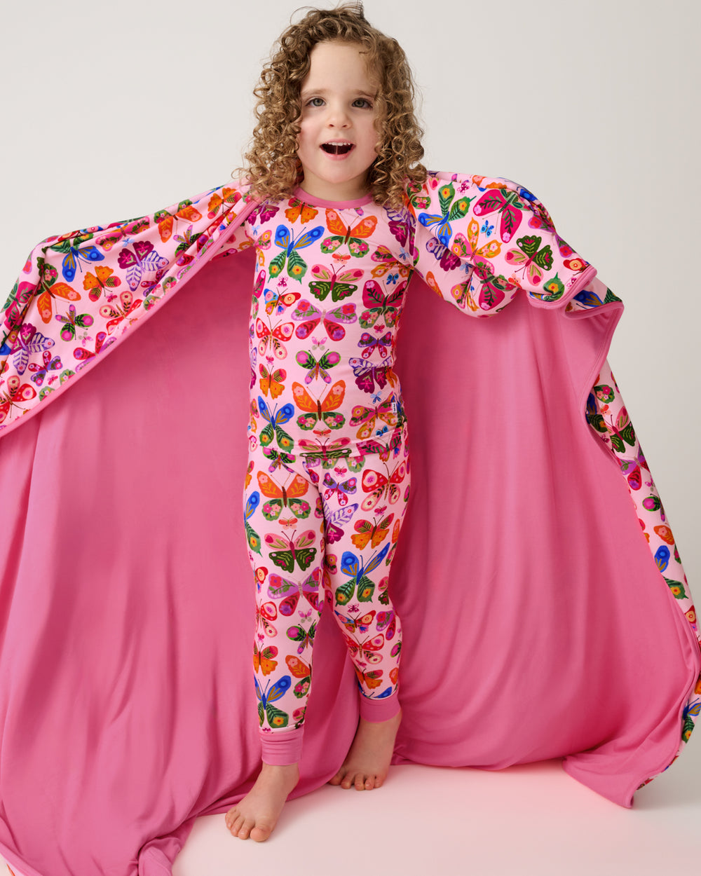Girl with the Flutter Garden Large Cloud Blanket® draped over her shoulders