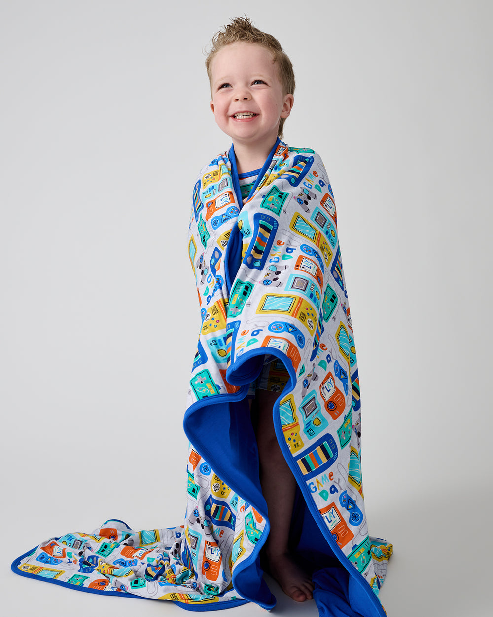 Standing boy wrapped in the Game On Large Cloud Blanket®