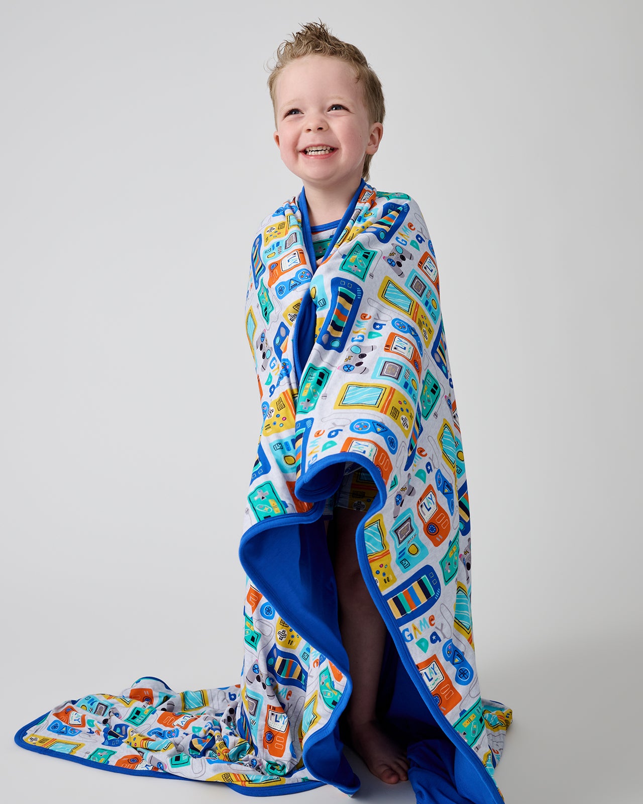Standing boy wrapped in the Game On Large Cloud Blanket®