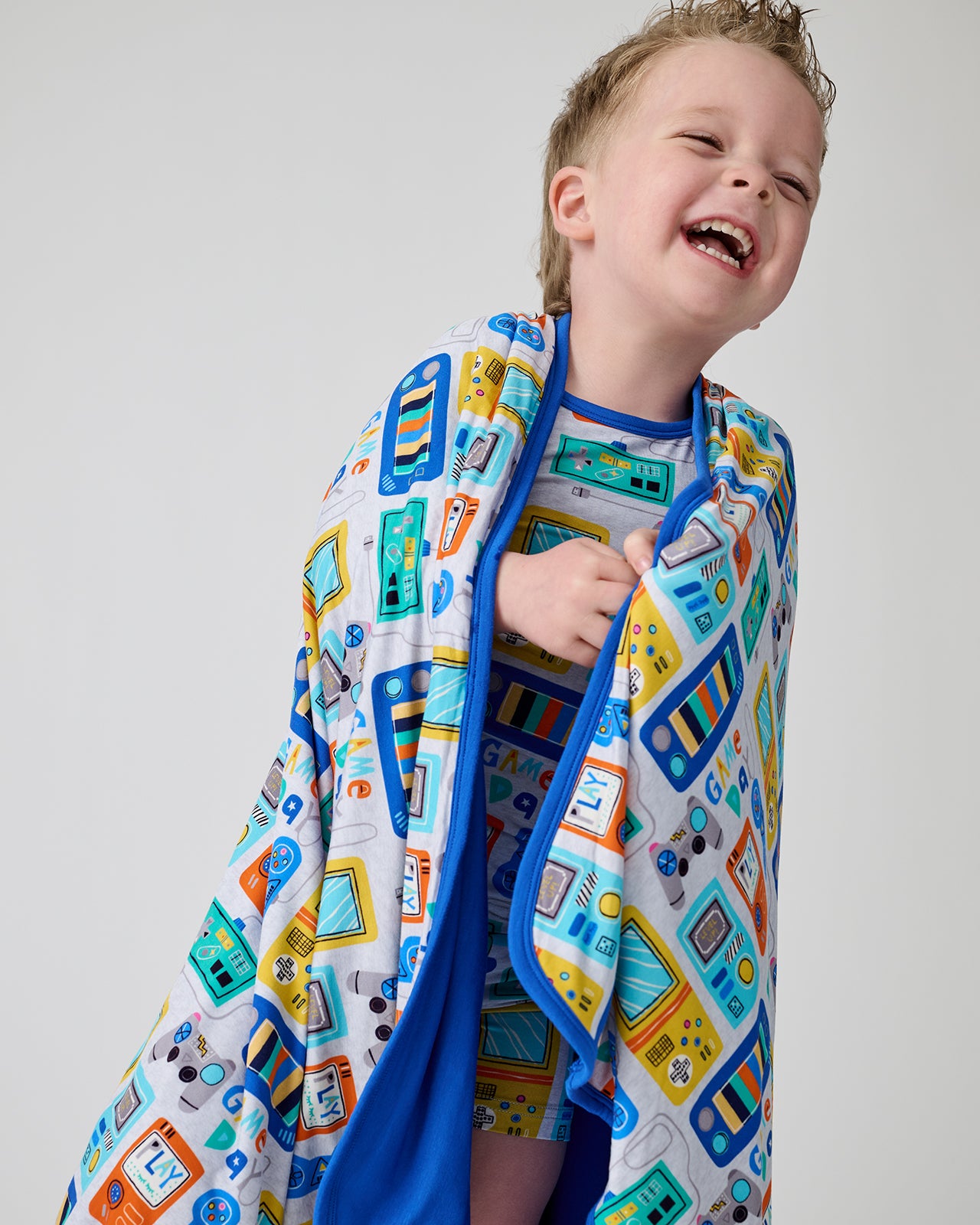 Laughing boy wrapped in the Game On Large Cloud Blanket®