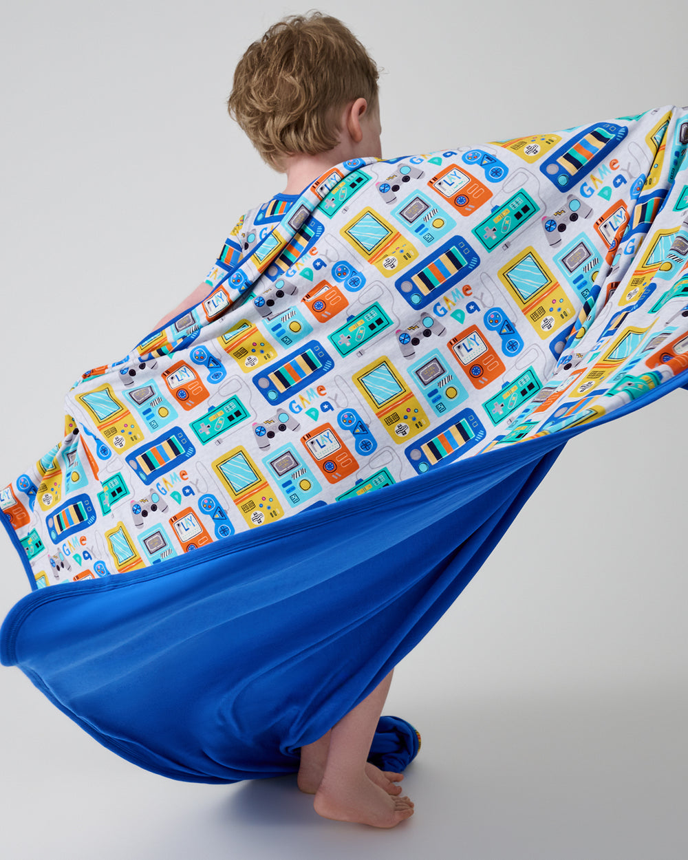 Child in motion holding the Game On Large Cloud Blanket®