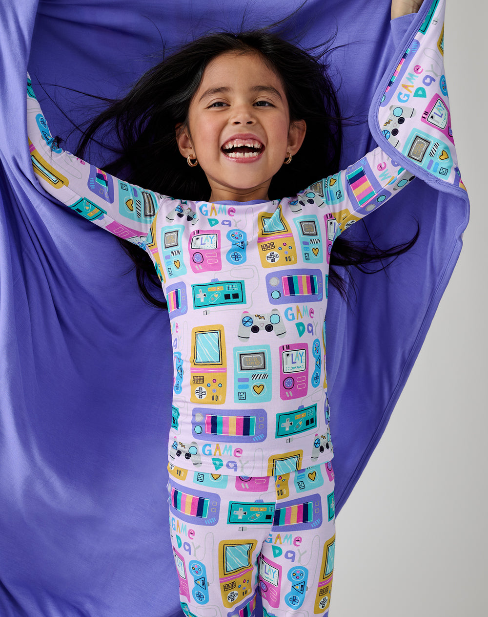 Girl holding the Purple Game On Large Cloud Blanket® showing the solid purple side