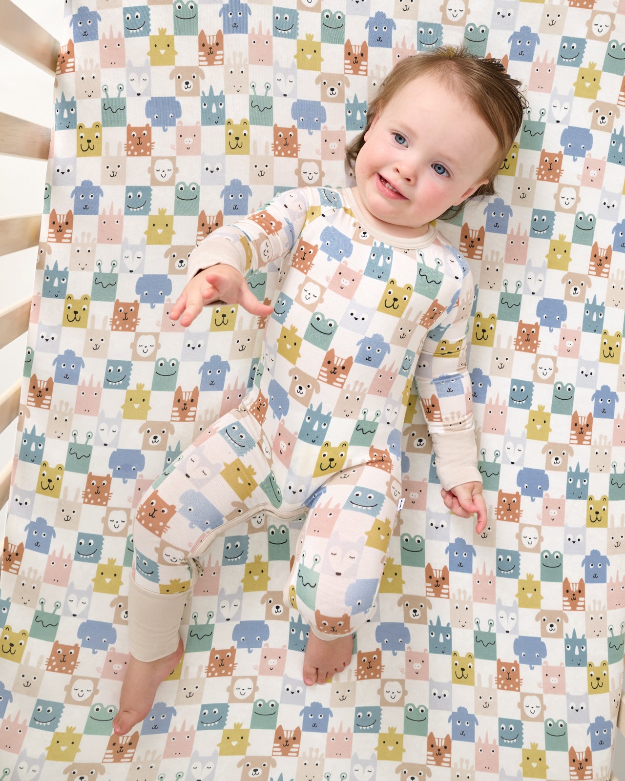 Aerial view of baby laying on the Check Mates Fitted Crib Sheet