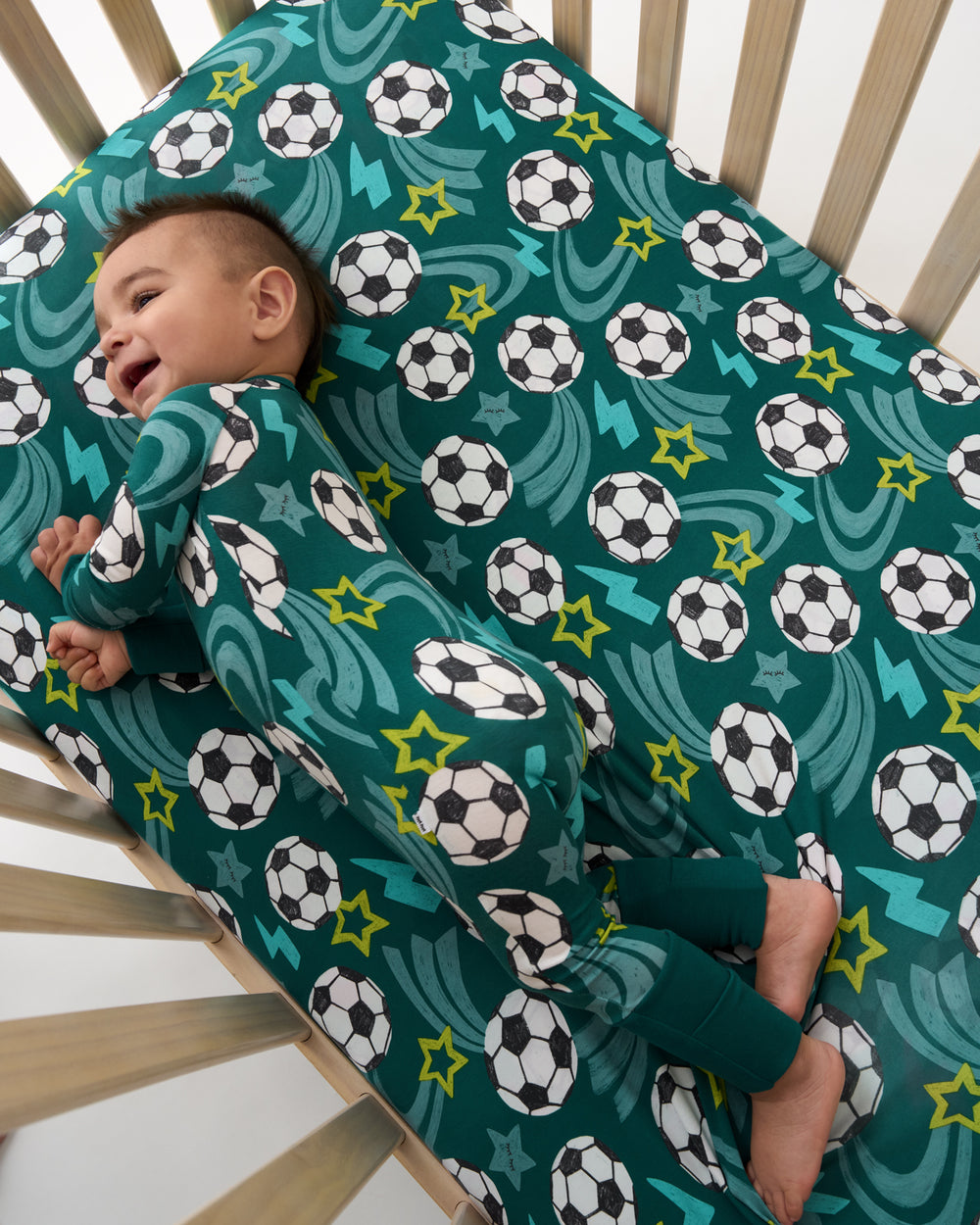 Aerial view of baby in a crib with the Soccer Stars Fitted Crib Sheet