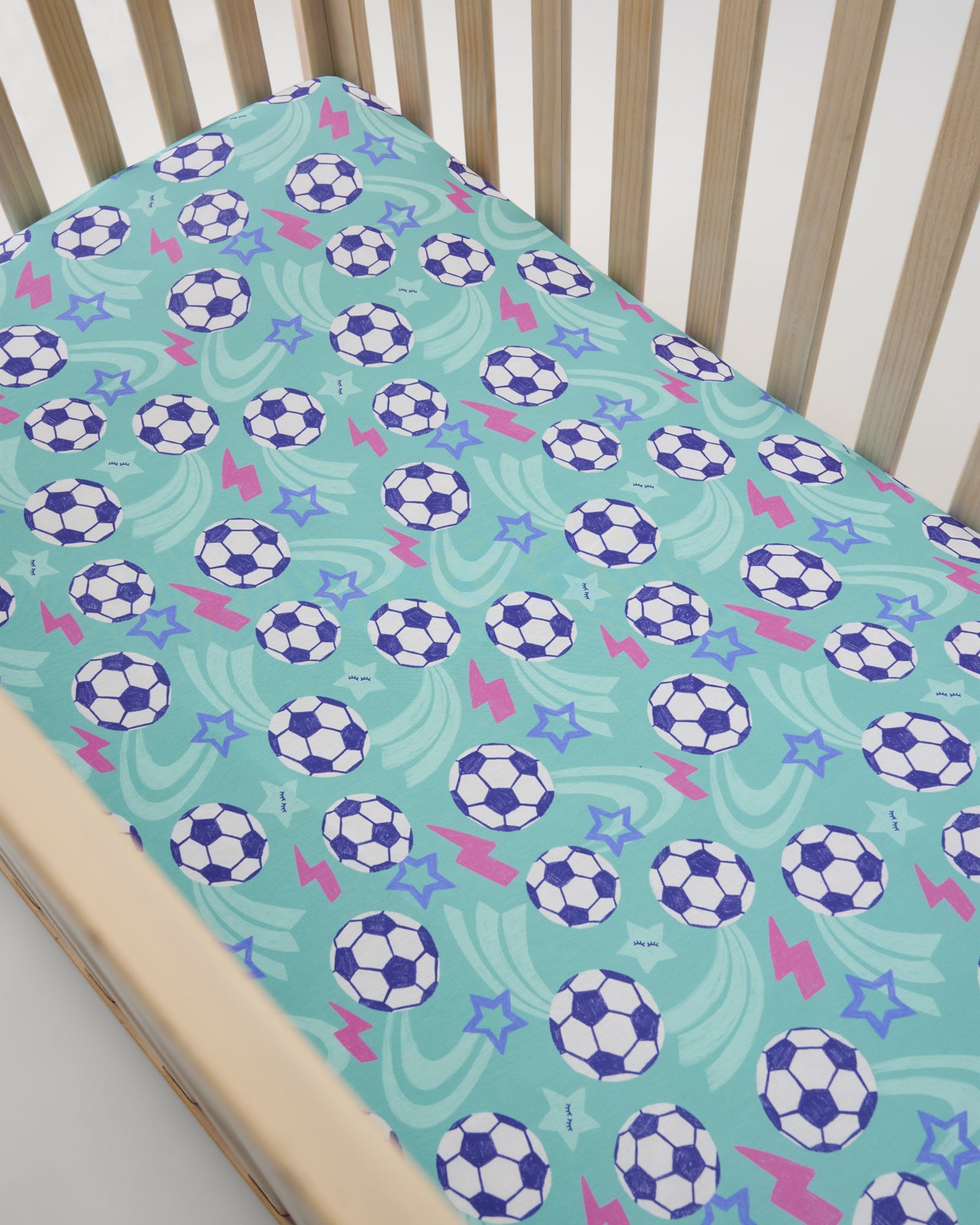 Overhead view of the Aqua Soccer Stars Fitted Crib Sheet