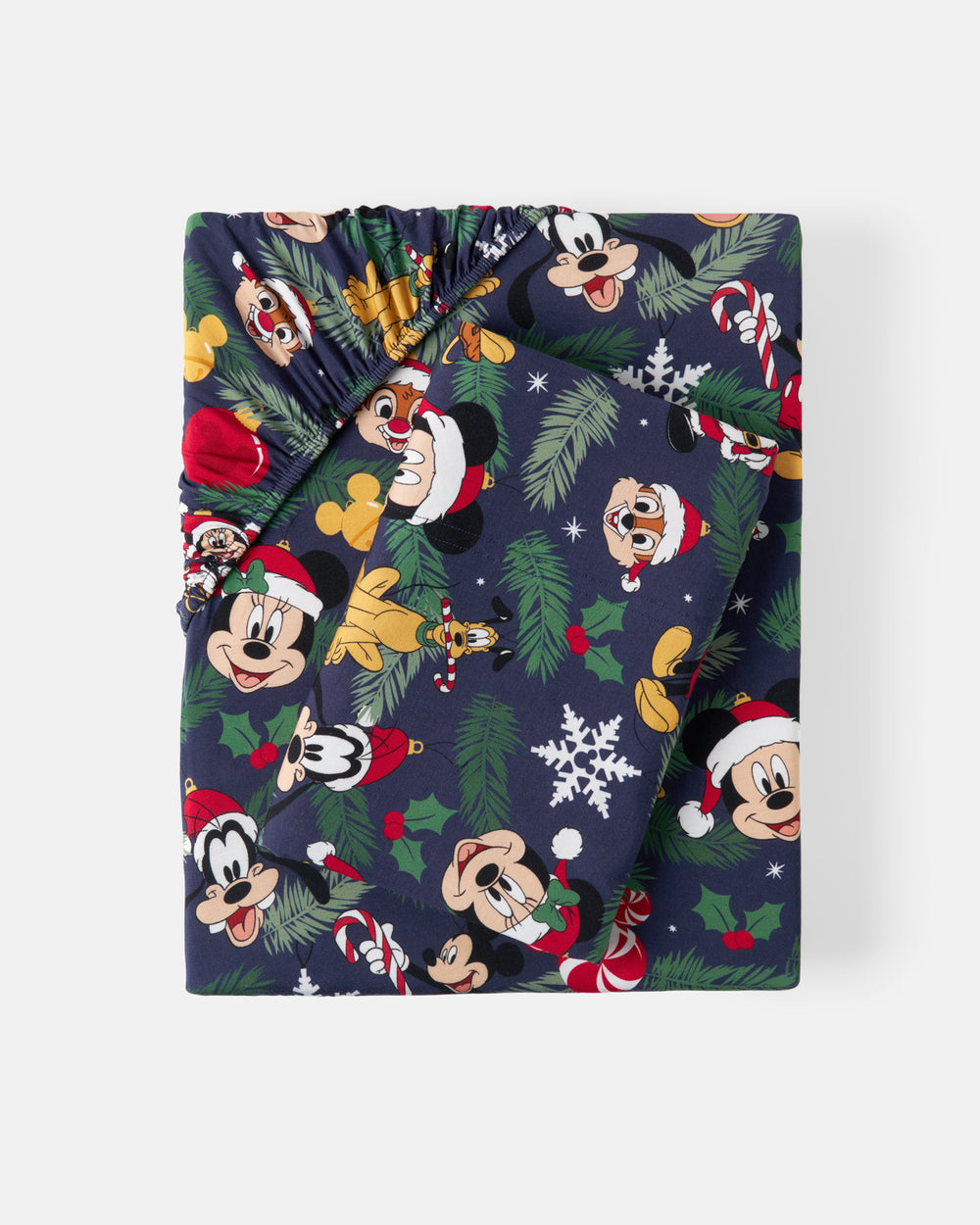 A folded Christmas-themed sheet set, likely a blanket or throw, featuring a navy blue background with a festive print of Disney characters including Mickey Mouse, Minnie Mouse, Goofy, and Donald Duck, along with pine branches, snowflakes, and holly.