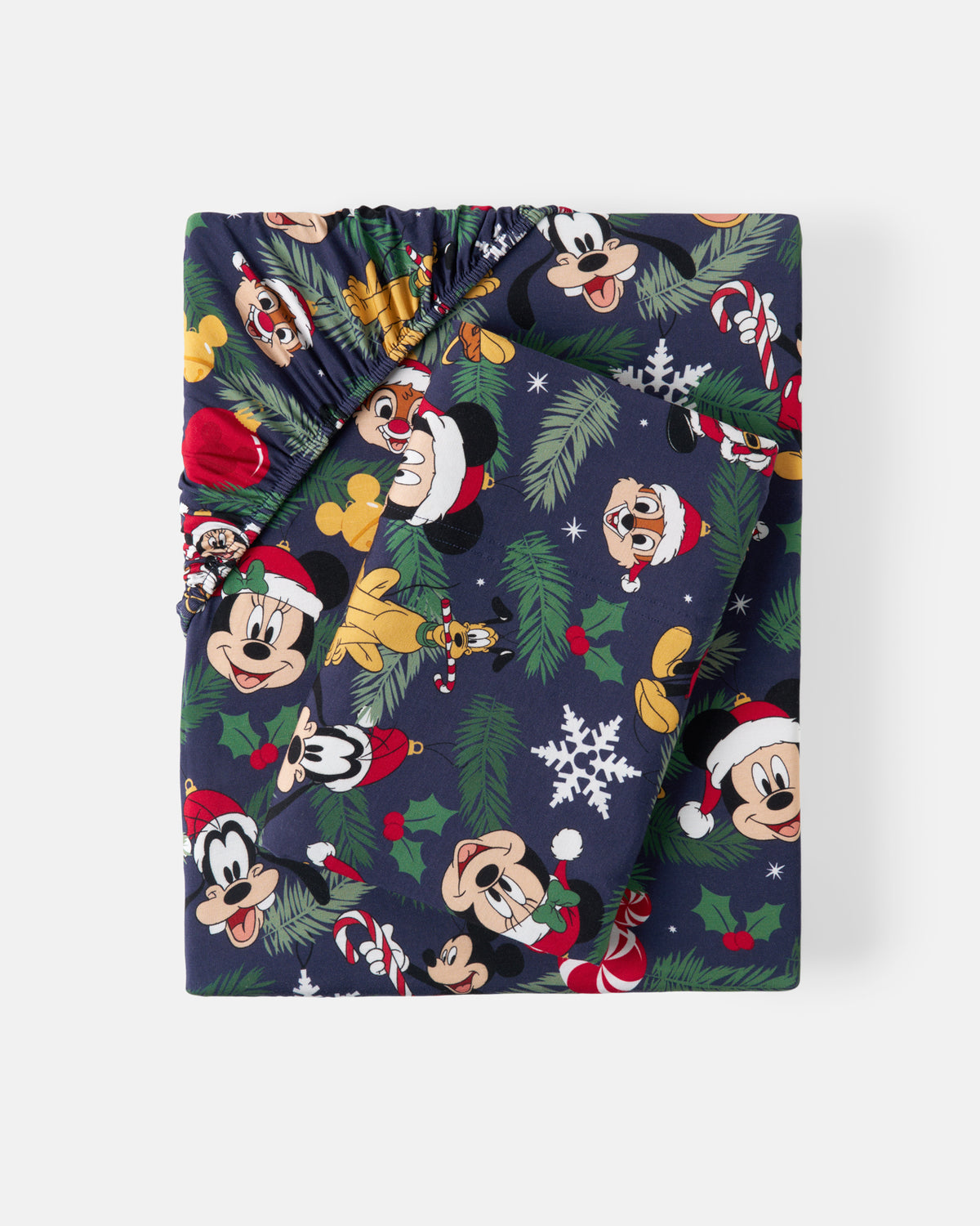 A folded Christmas-themed sheet set, likely a blanket or throw, featuring a navy blue background with a festive print of Disney characters including Mickey Mouse, Minnie Mouse, Goofy, and Donald Duck, along with pine branches, snowflakes, and holly.