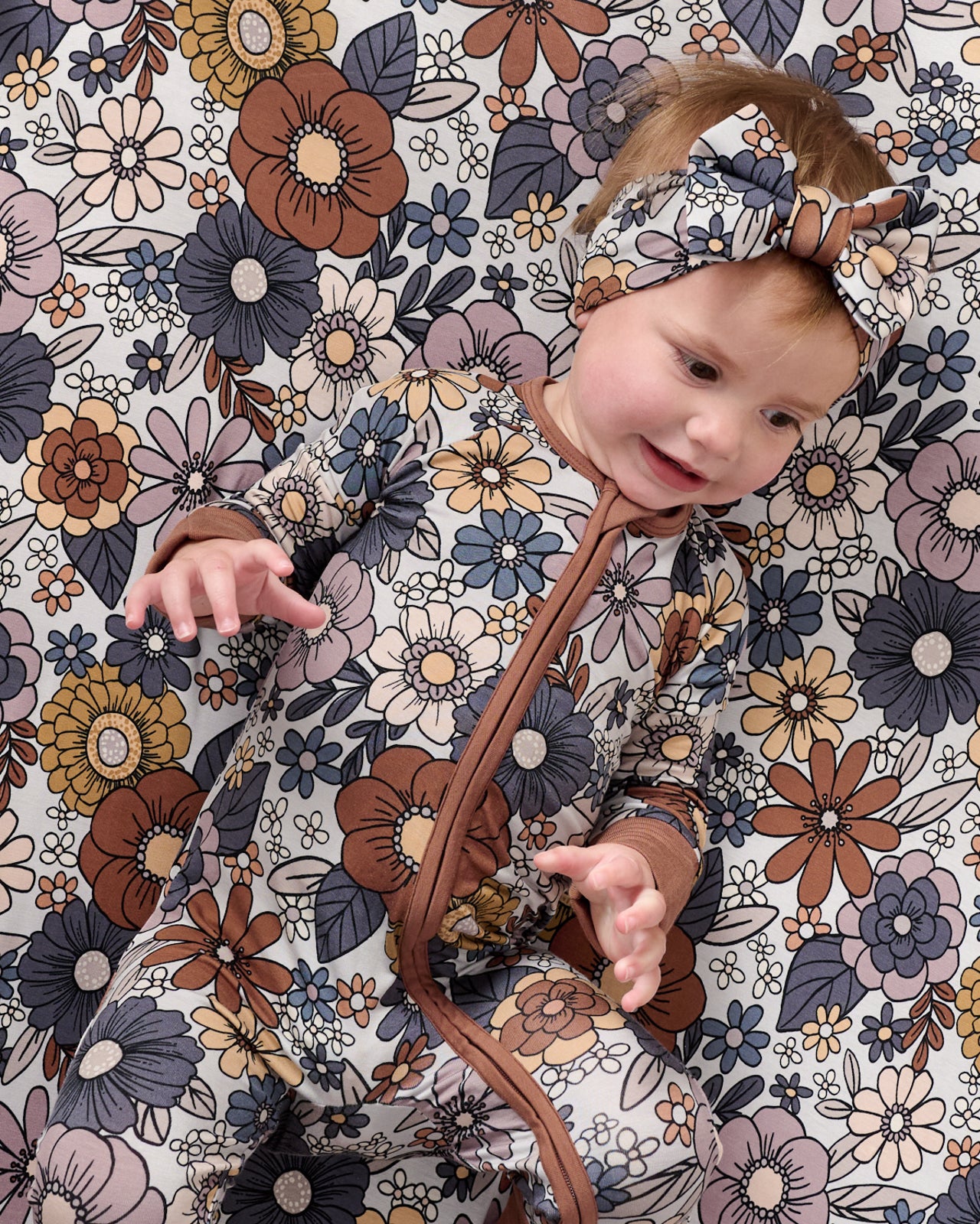 Baby laying on the Wildwood Floral Fitted Crib Sheet