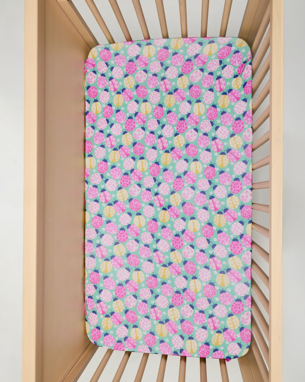 Overhead view of the Ladybug Meadow Fitted Crib Sheet