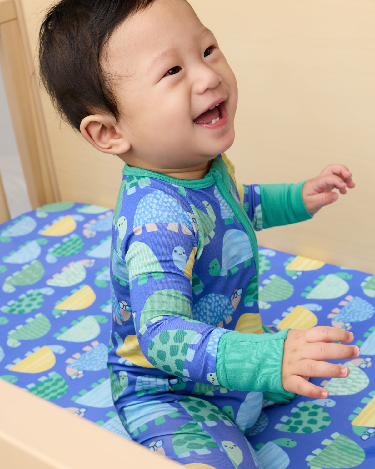 Baby sitting on the Shell Parade Fitted Crib Sheet
